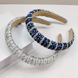 Close-up of wide velvet headband featuring luxury rhinestones and white pearls set on white block