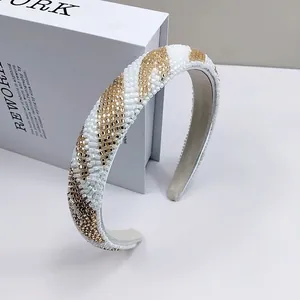 Dettaglio del cerchietto con perline bianche e oro metallizzato intrecciate a mano