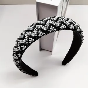 Detailweergave van de handgeweven zwart-witte kralen hoofdband met geometrische golfpatronen