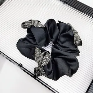 Detail of black satin hair scrunchie with three sparkling rhinestone butterfly charms