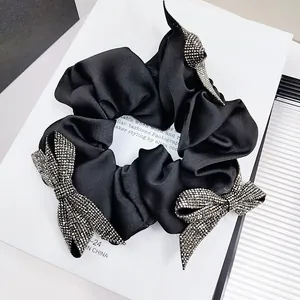 Elegant black satin scrunchie with three crystal butterfly accents on a clean white background