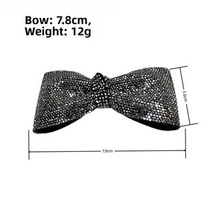 Dettaglio con dimensioni 7,8 cm x 3,8 cm del fermaglio fiocco con strass neri di lusso
