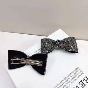 Dettaglio fronte e retro di fermagli per capelli a fiocco nero con strass luccicanti