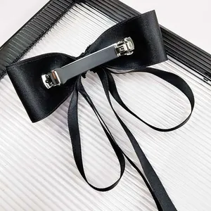Elegant black satin bow hair clip with long ribbons and metal spring fastener
