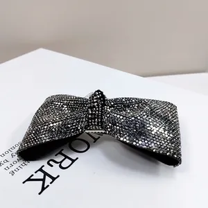 Dettaglio di un fermaglio a fiocco nero di lusso con strass argentati brillanti e clip