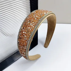 Close-up of a wide sparkling headband with champagne crystals and silver rhinestones