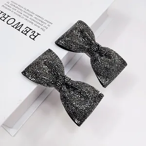 Elegante coppia di fermagli per capelli con fiocco di strass neri su libro bianco
