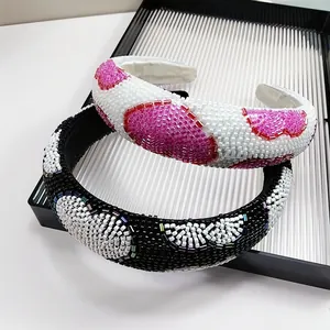 Detail of hand-sewn glass bead heart patterns on wide headbands with premium fabric lining
