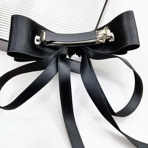 Detail view of the black satin bow hair clip with back metal spring fastener