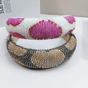 Close-up detail of hand-beaded heart pattern headbands with intricate glass seed beads