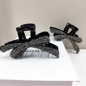 Paire d'élégantes pinces à cheveux noeud avec strass étincelants sur base en acrylique