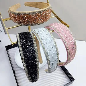 Detail of four crystal headbands in champagne, black, pink and white on a gold stand