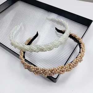 Close-up of luxury braided headbands with elegant cream and champagne pearls