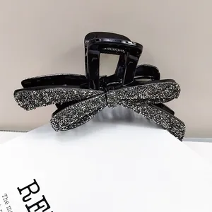 Détail d'une pince à cheveux nœud noir élégante avec des strass argentés étincelants