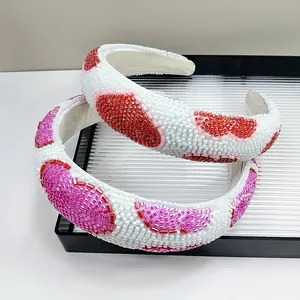 Close-up of handmade beaded headbands with colorful fruit patterns on white base