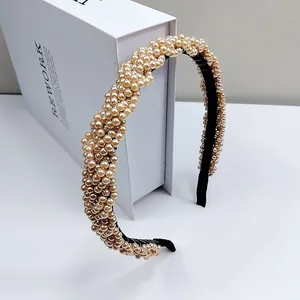 Detailed side view of champagne pearl headband with woven design on velvet base