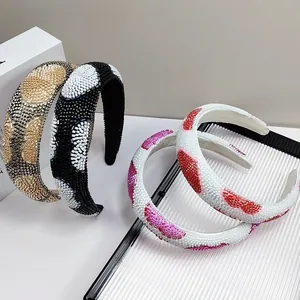Detail of four handmade beaded headbands with heart and polka dot patterns on wide bands