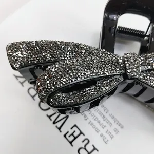 Pince à cheveux élégante avec nœud orné de strass noirs et finition brillante