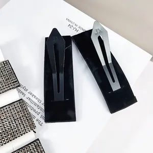 Matte black and frosted silver BB hair clips with JX engraving on velvet display card