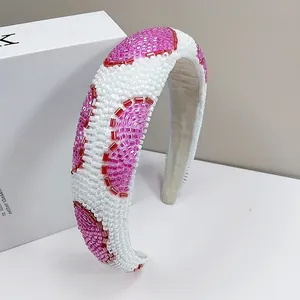 Detailed view of hand-beaded heart pattern with pink and red beads on a wide headband