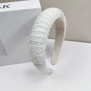 Close-up of padded headband featuring dense white faux pearls and clear faceted beads texture