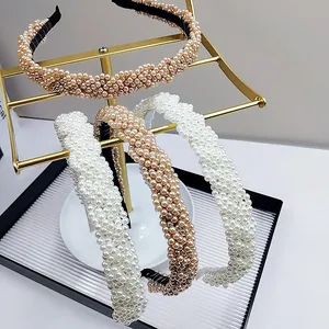 Close-up of pearl beaded headband set featuring braided texture on gold display stand