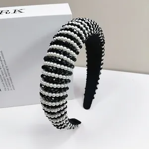 Detail of baroque headband with woven white pearls and black faceted beads on fabric