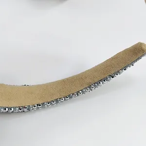 Close-up of beige velvet headband featuring high-density silver rhinestone edging