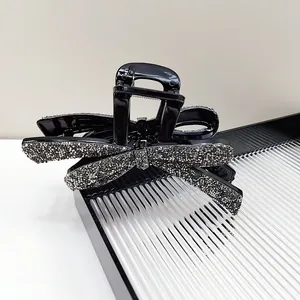 Grande pince à cheveux nœud noir élégante avec strass argentés scintillants et ressort