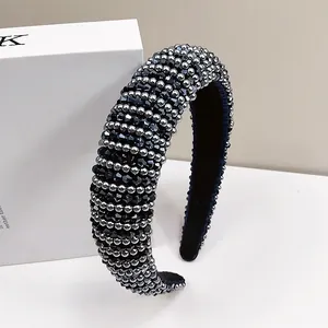 Detailed view of hand-stitched navy faceted beads and silver metal pearls on a velvet headband
