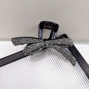 Grande pince à cheveux noire avec un nœud argenté scintillant et des strass