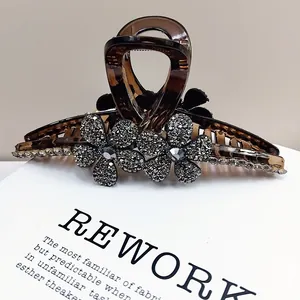 Détail macro d'une grande pince à cheveux marron ornée de fleurs en strass gris étincelants