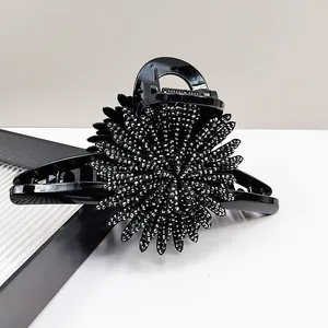 Close-up of a black sunflower hair claw clip with sparkling silver rhinestones
