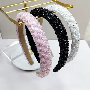 Details von Perlen-Stirnbändern in Rosa Schwarz und Weiß auf einem Goldständer
