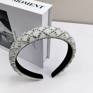 Detail of padded headband with sparkling rhinestones and white pearls on velvet fabric