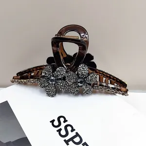 Détail d'une grande pince à cheveux écaille avec des fleurs élégantes en strass