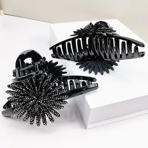 Detail shot of black sunflower hair claw clip with silver rhinestones on display box