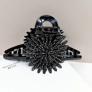 Detail of sunflower claw clip with black rhinestones and glossy resin finish