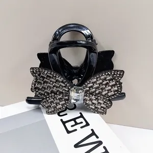 Détail d'une élégante pince à cheveux papillon noire avec strass et velours doux
