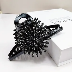 Close-up of large sunflower hair claw clip with black rhinestones and luxury finish