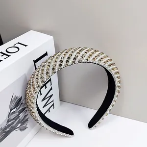 Close-up of wide headband with diagonal rows of white pearls and champagne rhinestones