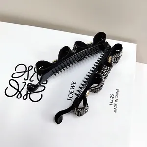 Close-up of black banana hair clip with shimmering rhinestones and secure plastic teeth