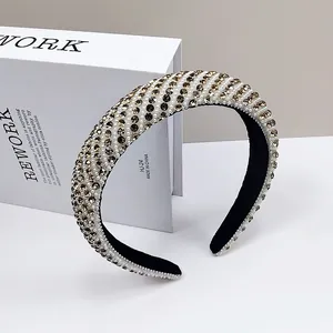Macro shot of thick padded headband with rows of faux pearls and amber crystals