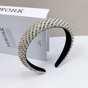 Close-up of wide headband with hand-stitched white pearls and champagne crystals