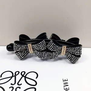 Elegant black banana hair clip with sparkling rhinestone bows and a secure vertical clasp