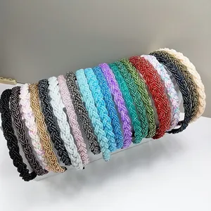 Vista detallada de diademas de cuentas de colores en varios tonos sobre un soporte de exhibición