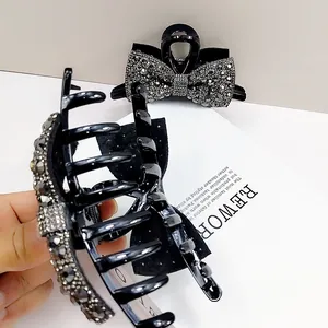 Elegant large black hair claw clip with sparkling rhinestones in a bow design