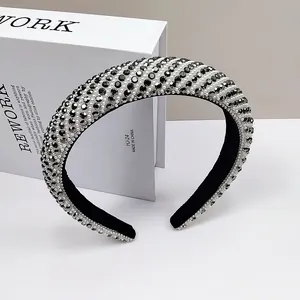 Detailed view of luxury wide headband with stripes, crystals and pearls on display box