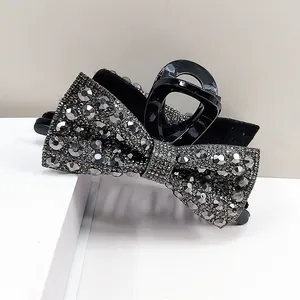 Sparkling black bow hair claw clip with silver rhinestones and crystal shark clip design