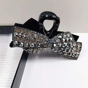 Close-up of black bow hair claw clip with pavé-set silver and smoky grey rhinestones